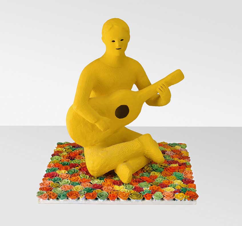 Flower that play 2002, Sculpture by Kazumasa Mizokami a yellow boy playing the guitar on the flower garden
