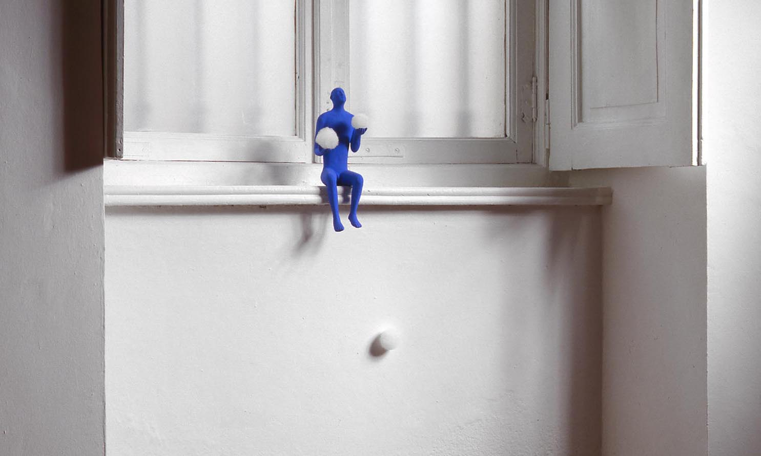Blue man 1995, Sculpture of Kazumasa Mizokami, A blue statue sitting on a windowsill, playing with two balls, exhibition of gallery Eva Menzio Turin photo Paolo Mussat Sartor