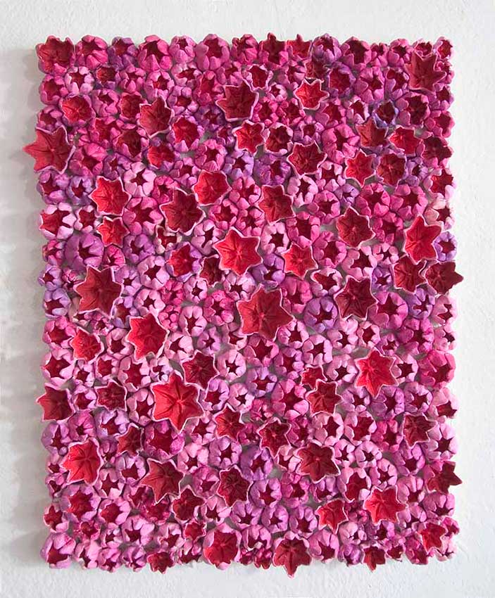 The red air 2008, Sculpture by Kazumasa Mizokami, Many 6-petalled flowers coloured red on the inside and smaller sized buds in pink on the outside in different shades put on a rectangular base. the-red-air
