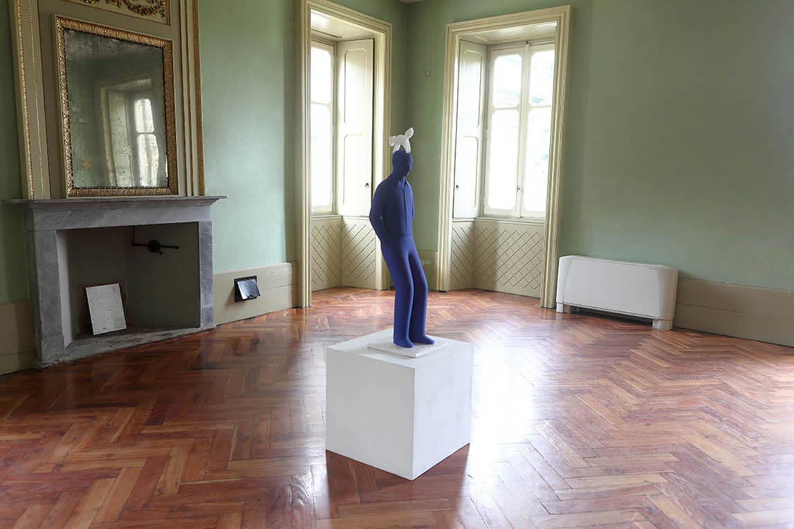 Shot of exhibitions-villa-filippin 2014 In the center of a large villa, a blue boy statue by Kazumasa Mizokami is placed on a white table and a translucent white squirrel is about to fly away from his head.