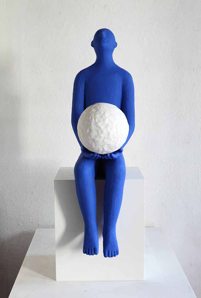 Blue man 2011, Sculpture by Kazumasa Mizokami, Blue statue sitting on a pedestal, holding a large white ball on his lap and looking up