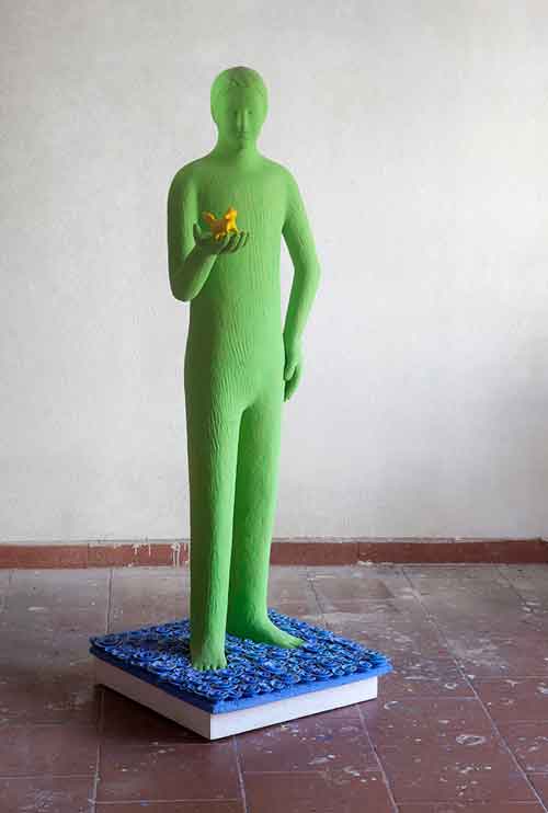 a statue of green boy holding a squirrel in his hand sculpture made by kazumasa mizokami