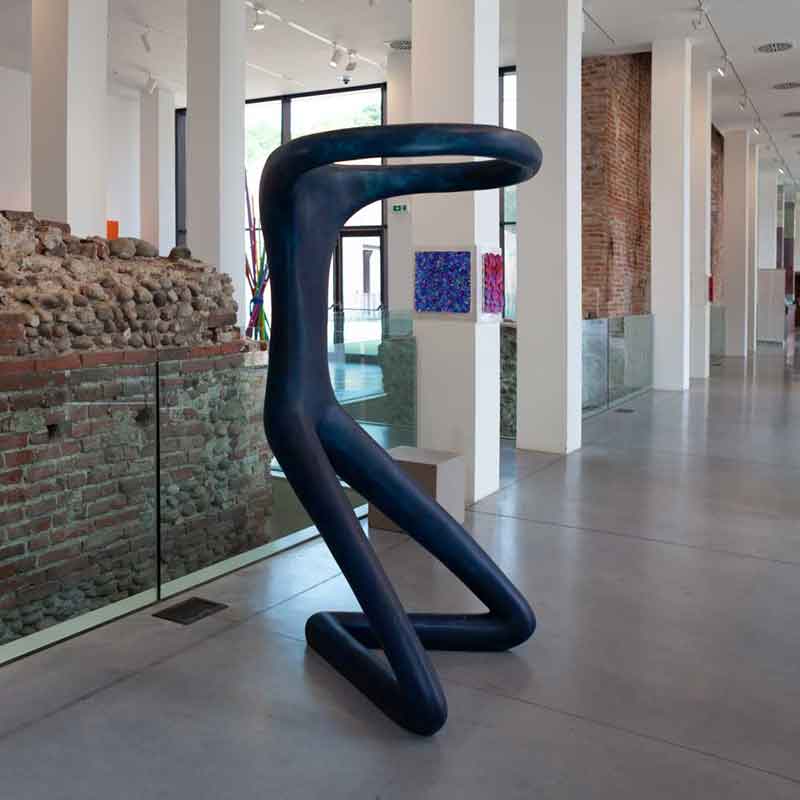 an abstract figure as if it were a sitting man with his arms forming a circle, half-transparent effect, glossy fiberglass with blue pigment, 100x70xh210cm