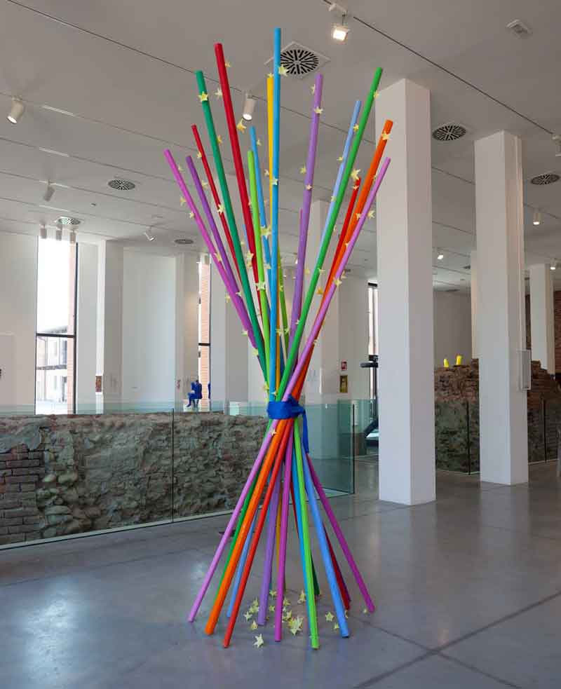 120x120xh300cm the work 18 colored sticks with 12 alcobalt colors joined by blue strings in the center and opened radiating under and above the whole stick attached small yellow plastic stars