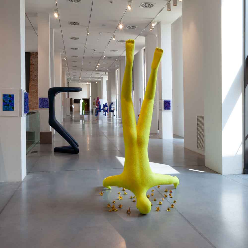 Large yellow figure 190x120x220cm which is arranged head turned as if it were falling from the head around many small unpaired yellow terracotta stars