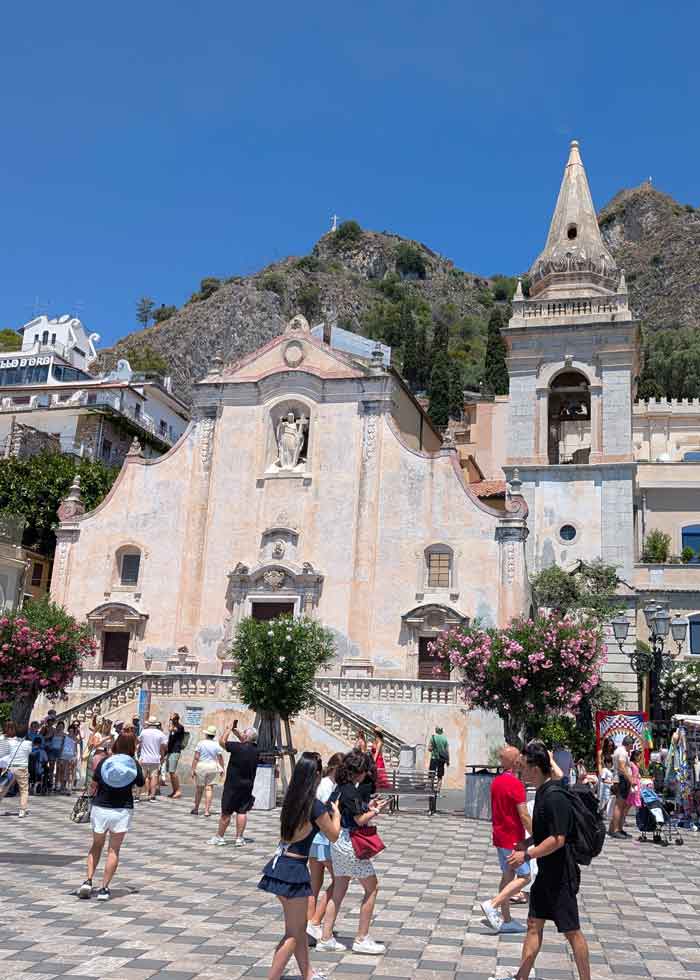 the square of Taormina in the background you can see a church and many tourists