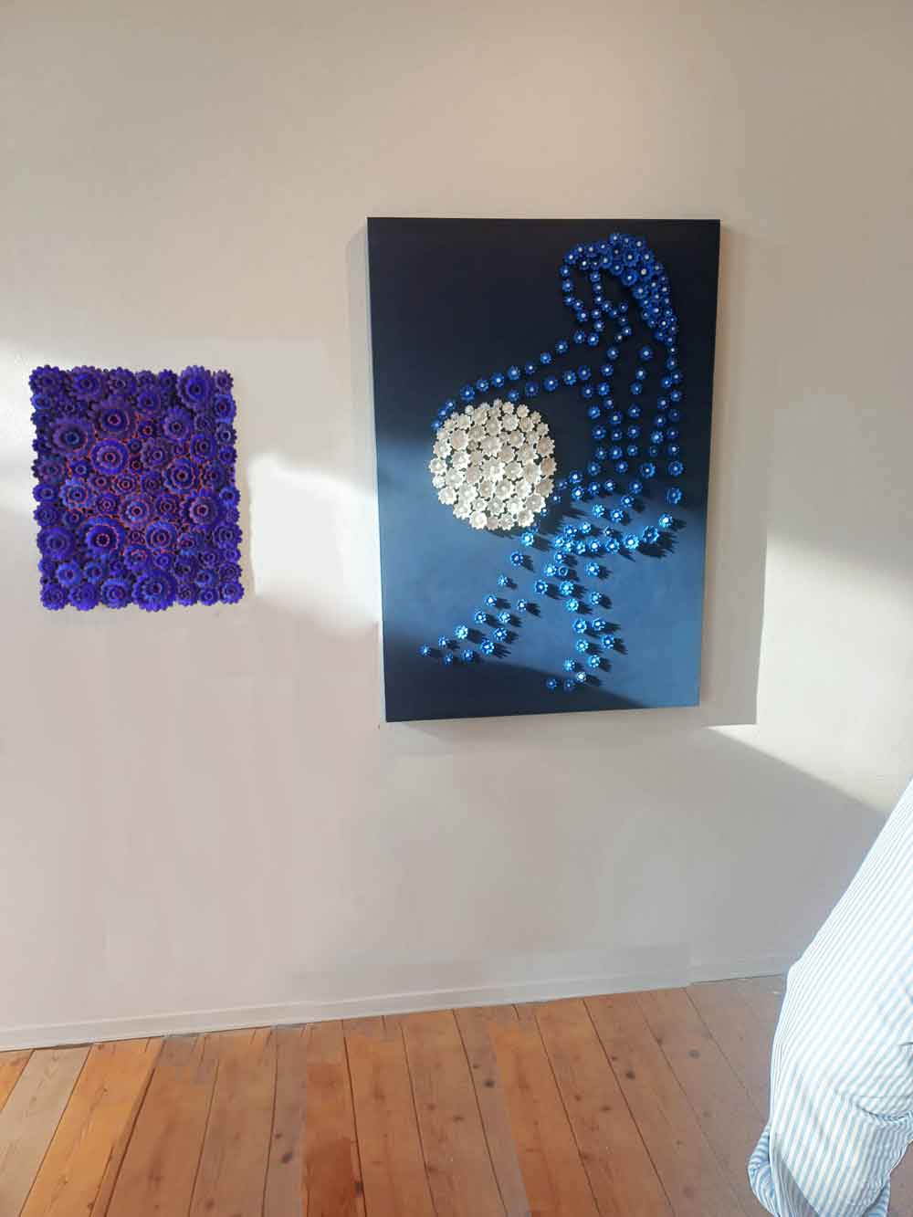 Of the two works on display, the one on the left is a 60 x 50 cm terracotta slab painted blue with numerous reliefs and a red circle in the center. The one on the right is a 120 x 90 cm painted slab with numerous daisy flowers painted on the terracotta, reminiscent of a couple holding a white moon. Both works are by Kazumasa Mizokami.